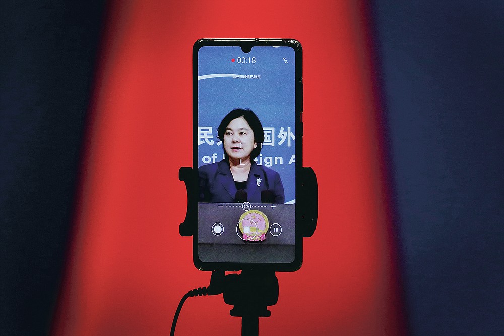 FILE - In this Sept. 1, 2020 file photo, a smartphone records Chinese Foreign Ministry spokeswoman Hua Chunying as she speaks during a daily briefing at the Ministry of Foreign Affairs in Beijing. "I'd like to stress that if the United States truly respects facts, it should open the biological lab at Fort Detrick, give more transparency to issues like its 200-plus overseas bio-labs, invite WHO experts to conduct origin-tracing in the United States," she said at a January 2021 MOFA press conference that went viral in China. (AP Photo/Andy Wong)