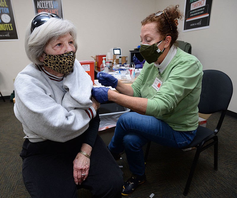 Lori Mahler (right) of Fayetteville administers a second dose of the covid-19 vaccine for Joyce Roberts of Springdale at Medical Arts Pharmacy in Fayetteville on Tuesday, Feb. 16, 2021. (NWA Democrat-Gazette/Andy Shupe)