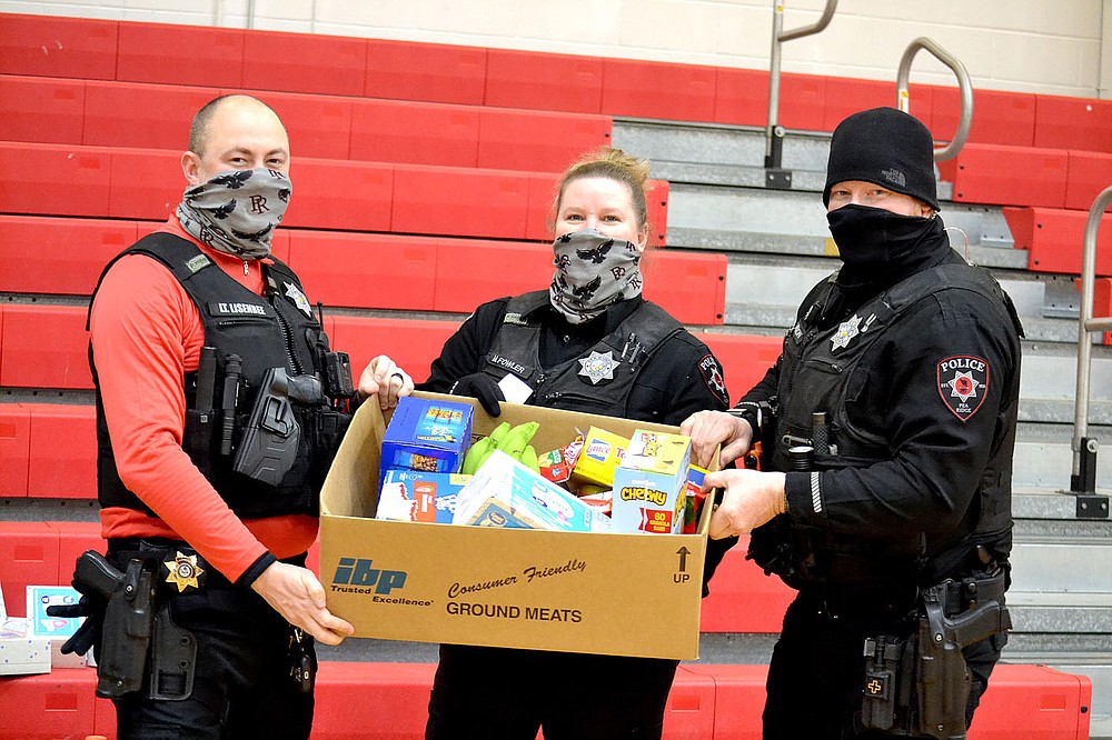 Pea Ridge Police Lt. Michael Lisenbee and officers Mindy Fowler and Justin Lawson helped distribute food and other supplies to families during the winter storm Wednesday, Feb. 17, 2021.