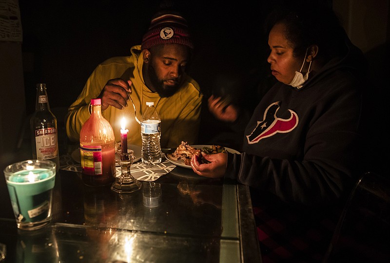 Howard and Nena Mamu eat dinner at their home in the Glenwood neighborhood in Hutto, Texas, Tuesday, Feb 16, 2021. Anger over Texas’ power grid failing in the face of a record winter freeze mounted Tuesday as millions of residents in the energy capital of the U.S. remained shivering with no assurances that their electricity and heat  — out for 36 hours or longer in many homes — would return soon or stay on once it finally does. (Ricardo B. Brazziell/Austin American-Statesman via AP)