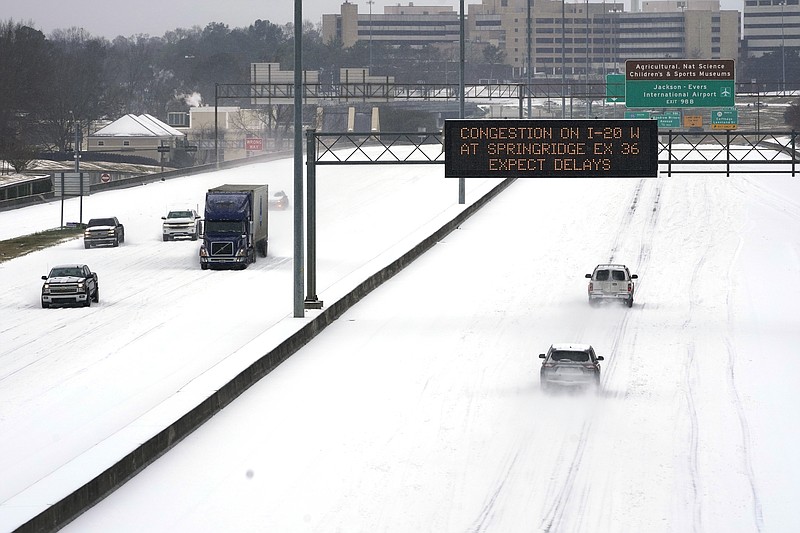 An electronic message board advises drivers of potential congestion on the intersecting interstate as they drive south on Interstate 55 in north Jackson, Miss., Monday, Feb. 15, 2021, as light snow mixed with sleet, and rain continue to cover much of the state. The National Weather Service forecasts temperatures barely hovering at 20 degrees Fahrenheit, and likely slipping into the single digits by Tuesday morning. A winter storm warning continues throughout the state. (AP Photo/Rogelio V. Solis)