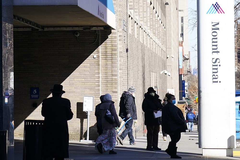People enter and exit Mount Sinai hospital Wednesday, Feb. 17, 2021, in New York. "Unfortunately, due to sudden changes in vaccine supply, we have been forced to cancel existing public vaccination appointments," said a hospital spokesperson. (AP Photo/Frank Franklin II)