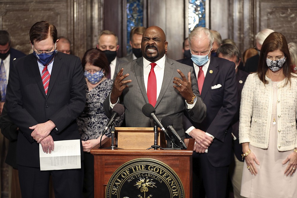 Greenwood pastor Tony Foster prays during a ceremony where South Carolina Gov. Henry McMaster signed a bill banning almost all abortions in the state on Thursday, Feb. 18, 2021, in Columbia, S.C. On the same day, Planned Parenthood filed a federal lawsuit to stop the measure from going into effect. (AP Photo/Jeffrey Collins)
