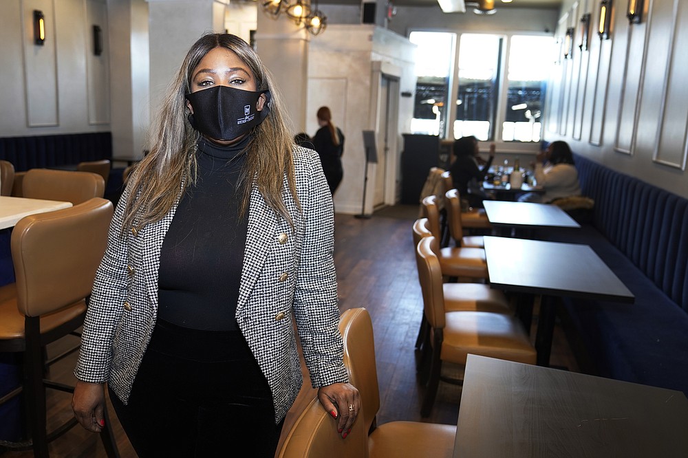 Nya Marshall, owner of Ivy Kitchen & Cocktails is seen in her restaurant, Saturday, Feb. 6, 2021 in Detroit. Marshall is worried about President Biden's plan to raise the minimum wage to $15 which could put her and other restaurants out of business in the middle of the pandemic. (AP Photo/Carlos Osorio)
