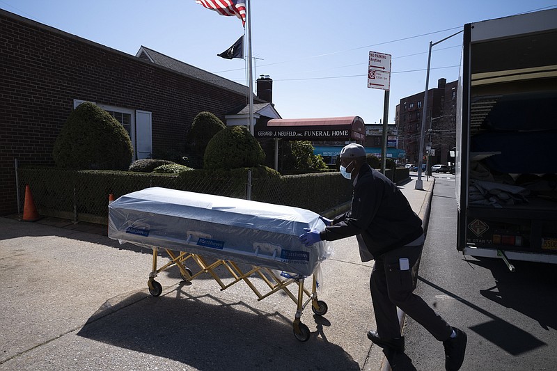 FILE - In this Friday, March 27, 2020 file photo, William Samuels delivers caskets to the Gerard Neufeld Funeral Home during the coronavirus pandemic in the Queens borough of New York. A report by the Centers for Disease Control and Prevention released on Thursday, Feb. 18, 2021 finds that life expectancy in the United States dropped a staggering one year during the first half of 2020 as the coronavirus pandemic caused its first wave of deaths. Minorities suffered the biggest impact, with Blacks losing nearly three years and Hispanics, nearly two years, according to preliminary estimates. (AP Photo/Mark Lennihan)