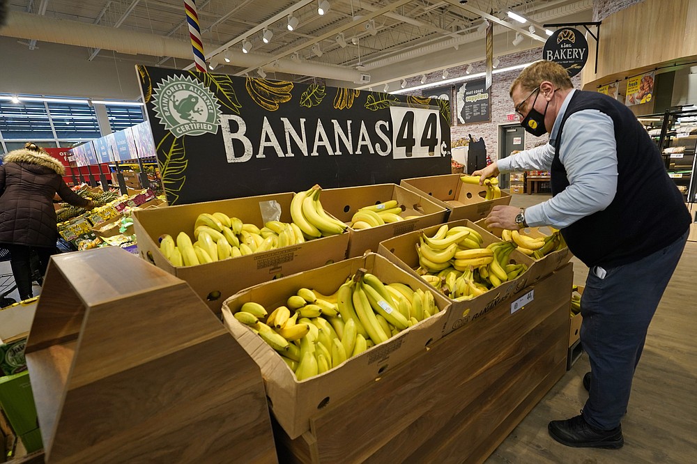 Lidl employee Joseph Lupo, arranges bananas in the produce aisle of the market where he works, Thursday, Feb. 4, 2021, in Lake Grove, N.Y. Earlier in the day, Lupo received the first dose of the coronavirus vaccine. The German grocery chain is offering $200 to any employee who gets vaccinated as an incentive. Lupo, who fell ill with the virus in March, was elated to get his first vaccine dose. "I never ever want to get COVID again, or see anybody else get it," said Lupo, 59. (AP Photo/Kathy Willens)