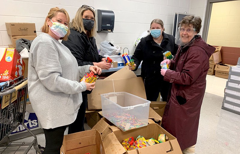 Photo submitted
Volunteers Rachel Hickman (left), Valerie King, P.J. Derwin and Terri Wubbena help sort through damaged school supplies after the Bright Futures donation room flooded on Wednesday.