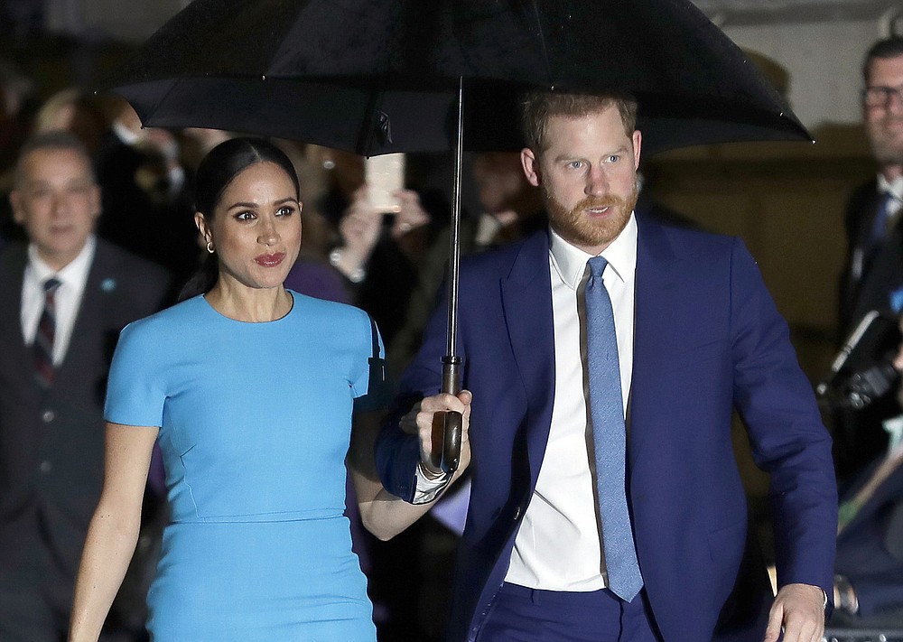 FILE - In this March 5, 2020 file photo, Britain's Prince Harry and Meghan, Duchess of Sussex arrive at the annual Endeavour Fund Awards in London. Harry and Meghan stepped away from full-time royal life in early 2020, and Buckingham Palace on Friday Feb. 19, 2021, confirmed the couple will not be returning to royal duties, and Harry will give up his honorary military titles. (AP Photo/Kirsty Wigglesworth, File)