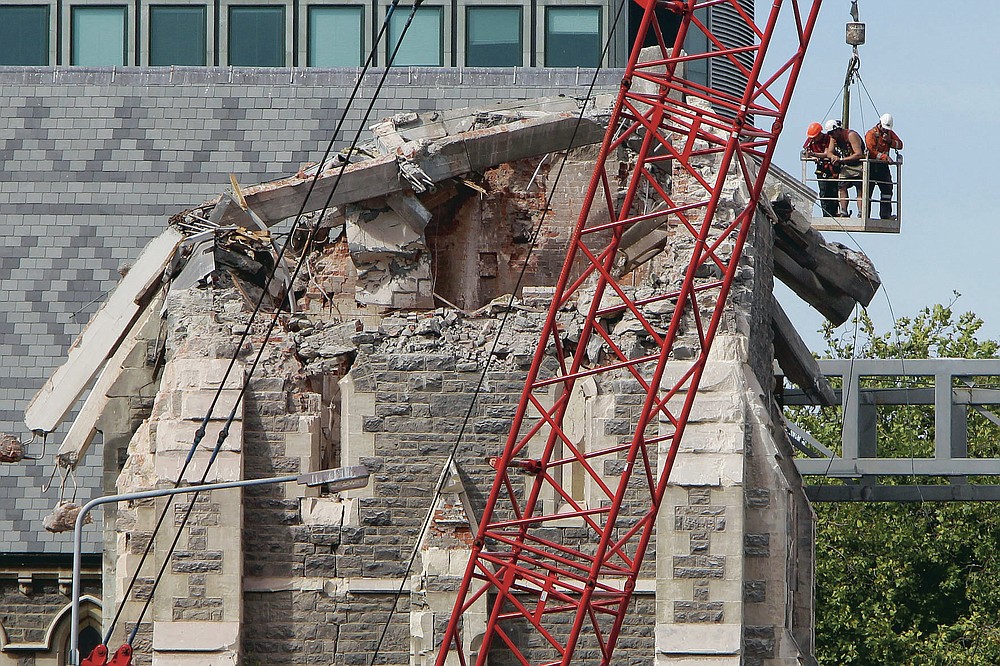 FILE - In this March 2, 2011, file photo, recovery workers inspect the fallen spire of Christ Church Cathedral following a magnitude 6.3 earthquake on Feb. 22, 2011 in Christchurch, New Zealand. One woman has used her anger to ensure buildings are safer. Others have found peace after heartbreaking losses. Ten years after the earthquake in Christchurch killed 185 people and devastated the city, some of those profoundly affected are sharing their journeys. (AP Photo/Mark Baker, Pool, File)