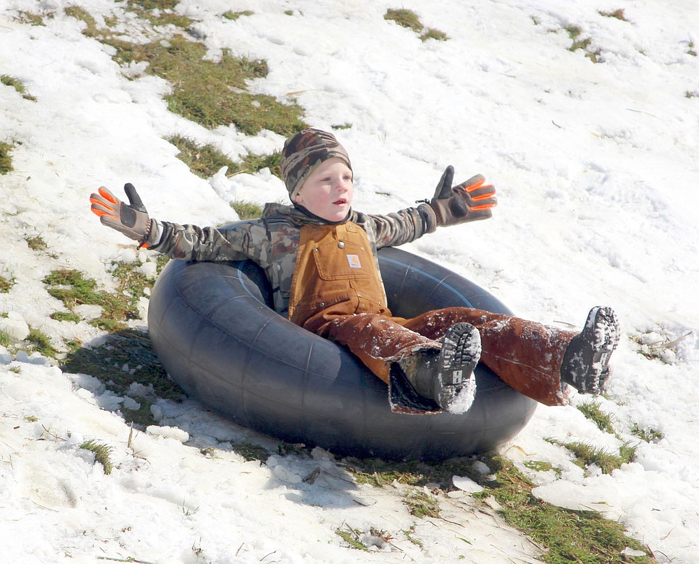 Keith Bryant/The Weekly Vista
Bentley Daylong, 6, splays out as he rides a tube down the snow-slicked Lake Ann dam after last week's snowstorm.