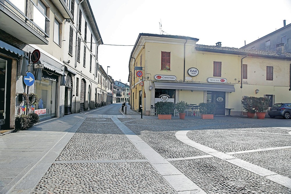 FILE - A deserted road in the town of Codogno, near Lodi, Northern Italy, in this Saturday, Feb. 22, 2020 file photo. Italy delivered the first shocking confirmation of locally transmitted coronavirus infections outside of Asia a year ago Sunday, with back-to-back revelations of cases more than 150 kilometers (nearly 100 miles) apart in the country's north. First, a 38-year-old man in Codogno, an industrial town in the Lombardy region, tested positive for COVID-19, sending panicked residents to pick up their children from school, stock up on provisions at grocery stores and search in vain for surgical masks at pharmacies.. (AP Photo/Luca Bruno)