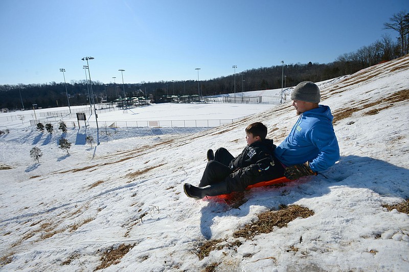 Austin Sutton (right) of Fayetteville and his son, Titan Sutton, 8, ride downhill Saturday, Feb. 20, 2021, near ball fields while sledding at Kessler Mountain Regional Park in Fayetteville. The Fayetteville City Council on Thursday approved a nearly $6.4 million construction contract to build a second four-field baseball complex at the park. Visit nwaonline.com/210221Daily/ for today's photo gallery. 
(NWA Democrat-Gazette/Andy Shupe)