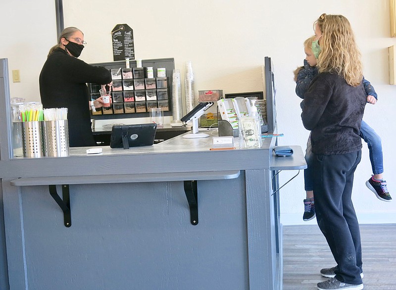 Westside Eagle Observer/SUSAN HOLLAND
Marisa Crain, owner of Gravette Nutrition, visits with a customer as she mixes up a specialty tea for the young mother. Crain offers a wide variety of healthy shakes and teas for persons of all ages and with a range of nutritional needs. There are drinks designed for persons wishing to lose weight, those wishing to gain weight and those who might want to bulk up for participating in athletics.