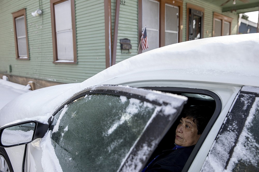 FILE - In this Tuesday, Feb. 16, 2021, file photo, Maria Pineda warms up in her car outside her home in East Austin, Texas, during a power outage caused by a winter storm. Pineda said her home has been without power since early Monday morning. (Jay Janner/Austin American-Statesman via AP, File)