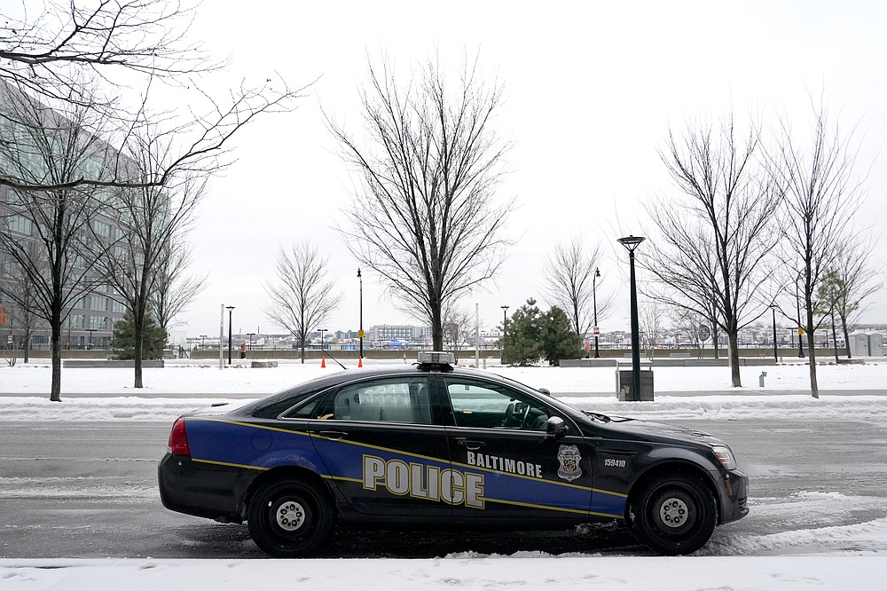 A Baltimore police cruiser is seen parked near a building while officers check on a call, Thursday, Feb. 18, 2021, in Baltimore. A package of police reforms in Maryland this year prompted by the death of George Floyd includes a proposed repeal of the Law Enforcement Officers Bill of Rights, the first-in-the-nation law implemented in 1974 that has been replicated in other states. (AP Photo/Julio Cortez)