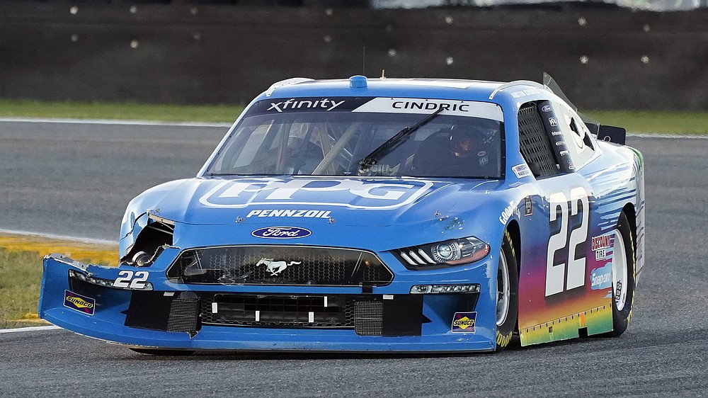 Austin Cindric (22) drives through a turn with damage to his front fender after he was involved in a crash during the NASCAR Xfinity Series road course auto race at Daytona International Speedway, Saturday, Feb. 20, 2021, in Daytona Beach, Fla. (AP Photo/John Raoux)