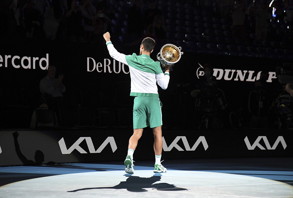 Serbia's Novak Djokovic holds the Norman Brookes Challenge Cup aloft after defeating Russia's Daniil Medvedev in the men's singles final at the Australian Open tennis championship in Melbourne, Australia, Sunday, Feb. 21, 2021.(AP Photo/Andy Brownbill)