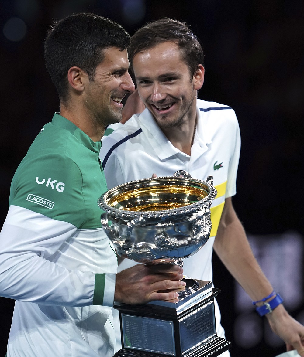 Serbia's Novak Djokovic, left, holds the Norman Brookes Challenge Cup as he talks with runner-up Russia's Daniil Medvedev after winning the men's singles final at the Australian Open tennis championship in Melbourne, Australia, Sunday, Feb. 21, 2021.(AP Photo/Mark Dadswell)