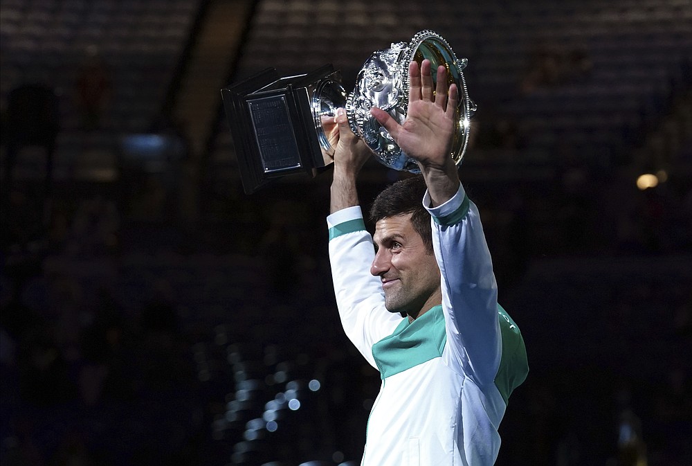 Serbia's Novak Djokovic holds the Norman Brookes Challenge Cup aloft after defeating Russia's Daniil Medvedev in the men's singles final at the Australian Open tennis championship in Melbourne, Australia, Sunday, Feb. 21, 2021.(AP Photo/Mark Dadswell)