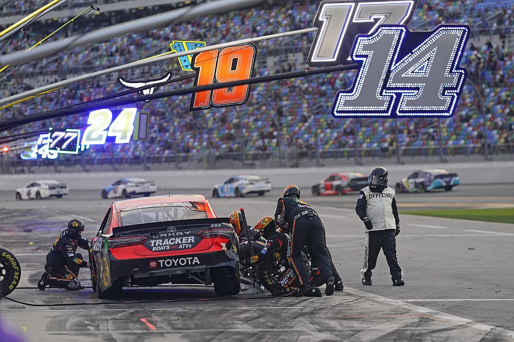 Martin Truex Jr.'s crew repairs damage to his car during a pit stop in the NASCAR Cup Series road course auto race at Daytona International Speedway, Sunday, Feb. 21, 2021, in Daytona Beach, Fla. (AP Photo/John Raoux)