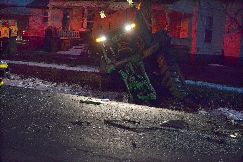 A six-ton tractor, minus its left rear wheel, sits in a front yard off Lee Town Road where it landed after being struck from behind by a 2013 Dodge mini-van Sunday shortly before 6:30 p.m.