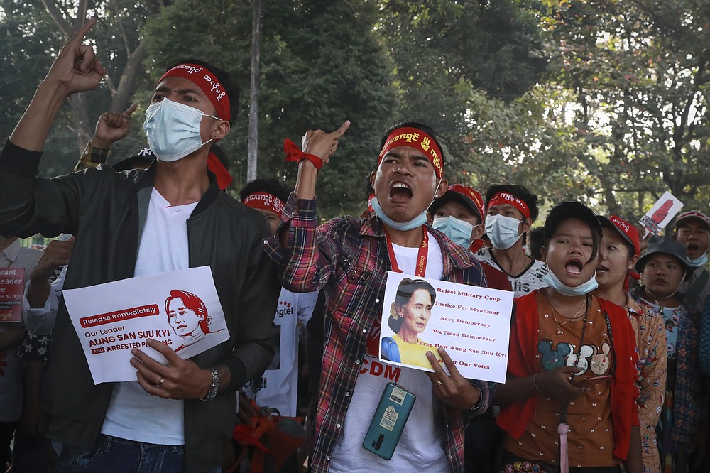 Protesters shout slogans and display images of ousted leader Aung San Suu Kyi during an anti-coup protest in Yangon, Myanmar, Sunday, Feb. 21, 2021. Police in Myanmar shot dead at least a few anti-coup protesters and injured several others on Saturday as security forces increased pressure on popular revolt against the military takeover. (AP Photo)