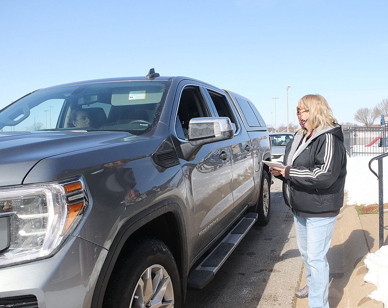 LYNN KUTTER ENTERPRISE-LEADER
Jill Simpson, a member of Farmington United Methodist Church, talks to a visitor during the church's monthly drive-through food pantry Saturday morning. Almost all of the food given away Saturday was made possible through Boy Scout Troop 555's recent food drive. The church also receives food donations from Life Ministries and other churches and organizations. The drive-through is held the third Saturday of the month.