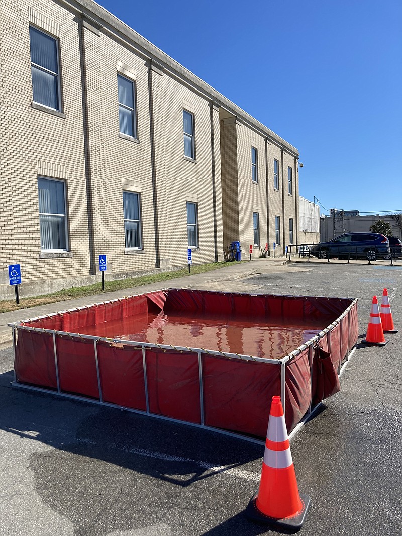 A temporary water trough has been placed in the parking lot of the Jefferson County Courthouse. The water is used to flush toilets in the building because the water pressure is too low. "Every office has a bucket," one worker said. (Pine Bluff Commercial/Byron Tate)