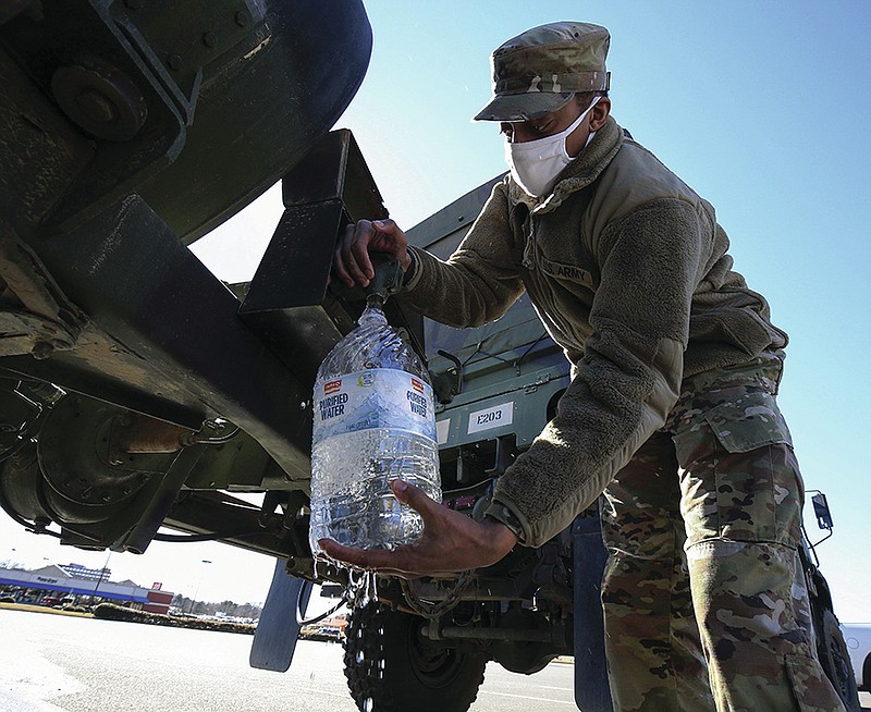PVC Terry Johnson with E Company, 39th IBCT of the Arkansas National Guard fills water bottles Monday Feb. 22, 2021 in Benton as residents remained under a boil order following last weeks winter storms. The water distribution sites at the Benton Events Center and the Benton River Center will be open again today (Tuesday) and residents should bring their own containers to fill with potable water. (Arkansas Democrat-Gazette/Staton Breidenthal)