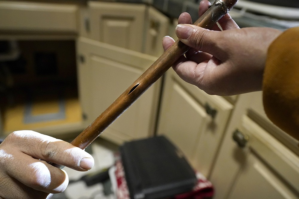 CORRECTING LAST NAME TO VALERIO, NOT VALERIA - Handyman Roberto Valerio, left, hands homeowner Nora Espinoza the broken pipe after removing it from under her sink in Dallas on Saturday, February 20, 2021.  (AP Photo / Tony Gutierrez)