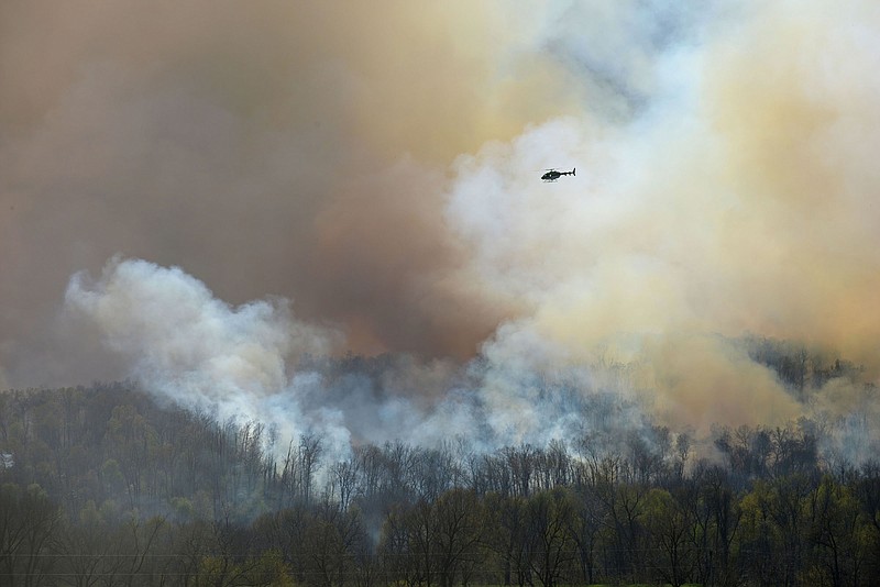 NWA Democrat-Gazette/BEN GOFF
A helicopter circles a plume of smoke on Monday April 4, 2016 rising from the Ozark National Forest west of Tontitown as seen from Robinson Road.