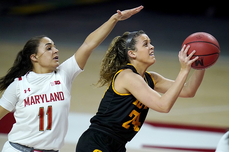 Iowa guard Gabbie Marshall, right, shoots a basket against Maryland guard Katie Benzan during the first half of an NCAA college basketball game, Tuesday, Feb. 23, 2021, in College Park, Md. (AP Photo/Julio Cortez)