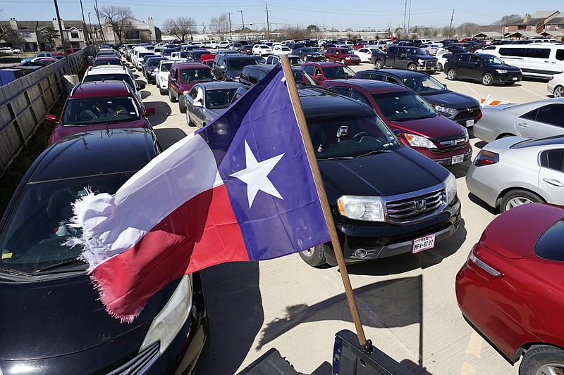 Hundreds of a vehicles are staged in a parking lot as people wait in line at a food and water distribution site Monday, Feb. 22, 2021, in Houston. The city's boil water notice has been rescinded however many residents lack water at home due to broken pipes. (AP Photo/David J. Phillip)