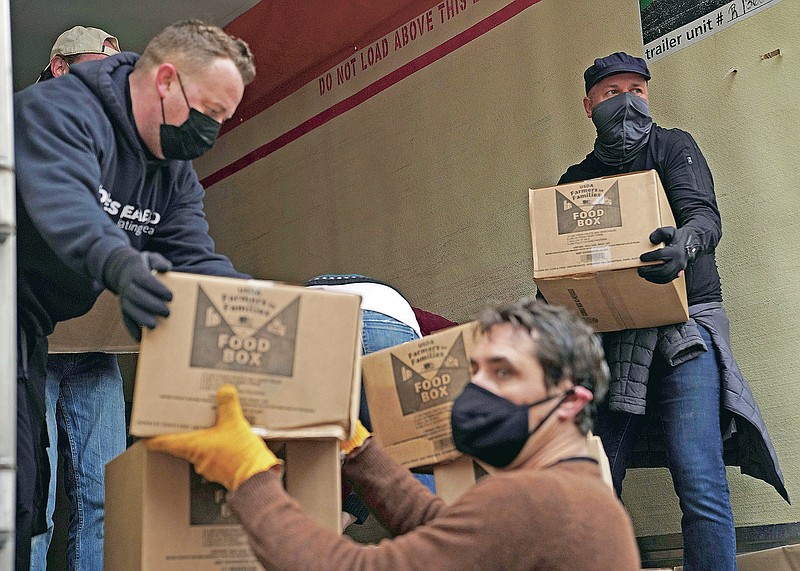 Volunteers unload boxes of food from a truck for a distribution program run through Mosaic West Queens Church in the Sunnyside neighborhood of the Queens borough of New York on Monday, Feb. 22, 2021. The program gives out more than 1,000 boxes of food to families twice a week. (AP Photo/Emily Leshner)