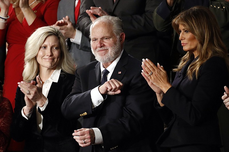 FILE - In this Feb. 4, 2020 file photo, Rush Limbaugh reacts as first Lady Melania Trump, and his wife Kathryn, applaud, as President Donald Trump delivers his State of the Union address to a joint session of Congress on Capitol Hill in Washington.  Limbaugh, the talk radio host who became the voice of American conservatism, has died. (AP Photo/Patrick Semansky, File)