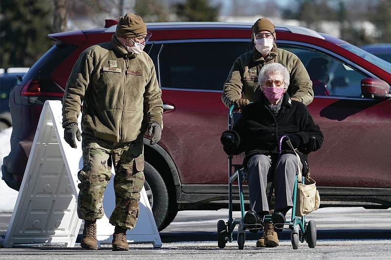 A patient is assisted by National Guardsmen upon arriving at the COVID-19 vaccination site at the Augusta Civic Center, Friday, Feb. 26, 2021, in Augusta, Maine. Gov. Janet Mills said Mainers ages 60 and older may get the vaccine starting Wednesday, March 3. (AP Photo/Robert F. Bukaty)