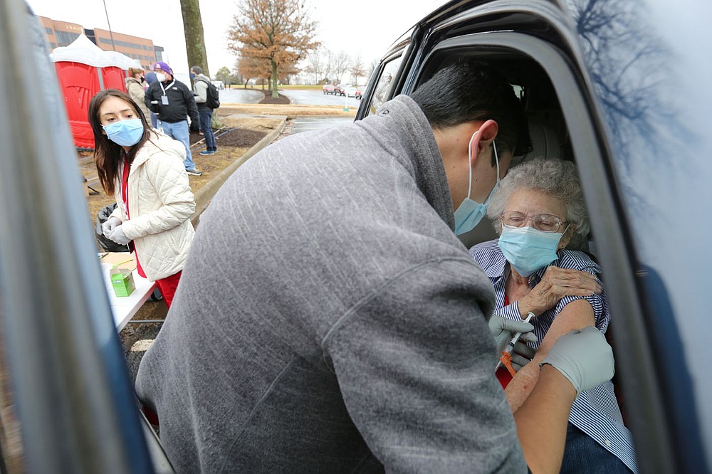 Zelma "Rita"? Stuckey receives a Moderna covid-19 vaccination shot Friday from Albert Carabajo, a J1 student in the Eleanor Mann School of Nursing at the University of Arkansas, during a drive thru mass vaccination clinic hosted by the Northwest Arkansas Council at J.B. Hunt Transport Corporate Headquarters in Lowell. Multiple area health providers participated in the event that planned on administering 3,000 doses of the Moderna vaccine to those with confirmed appointments. Check out nwaonline.com/210227Daily/ and nwadg.com/photos for a photo gallery.
(NWA Democrat-Gazette/David Gottschalk)