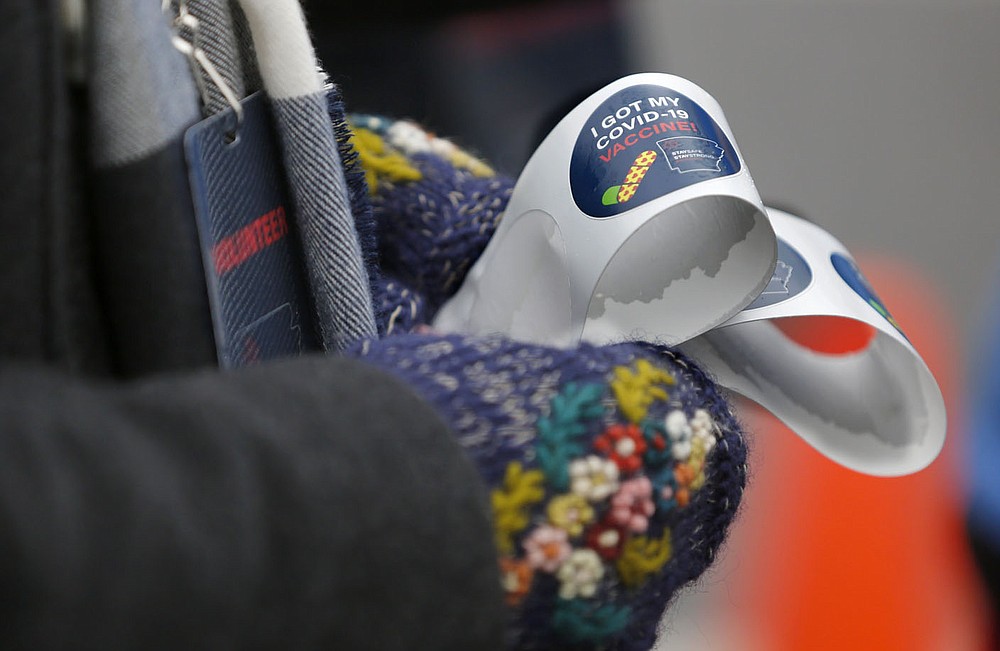 Paula Dutton, a nurse volunteer, holds stickers for distribution Friday, February 26, 2021, during a drive thru mass vaccination clinic hosted by the Northwest Arkansas Council at J.B. Hunt Transport Corporate Headquarters in Lowell. Multiple area health providers participated in the event that planned on administering 3,000 doses of the Moderna vaccine to those with confirmed appointments. Check out nwaonline.com/210227Daily/ and nwadg.com/photos for a photo gallery.
(NWA Democrat-Gazette/David Gottschalk)
