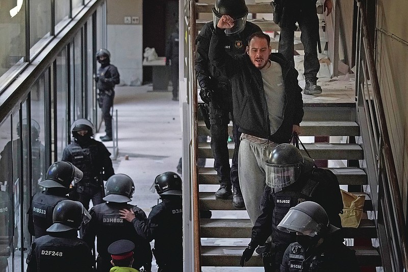 Rap singer Pablo Hasel is detained by police officers at the University of Lleida, Spain, Tuesday, Feb. 16, 2021. The imprisonment of Pablo Hasel for inciting terrorism and refusing to pay a fine after having insulted the country's monarch has triggered a social debate and street protests. (AP Photo/Joan Mateu)