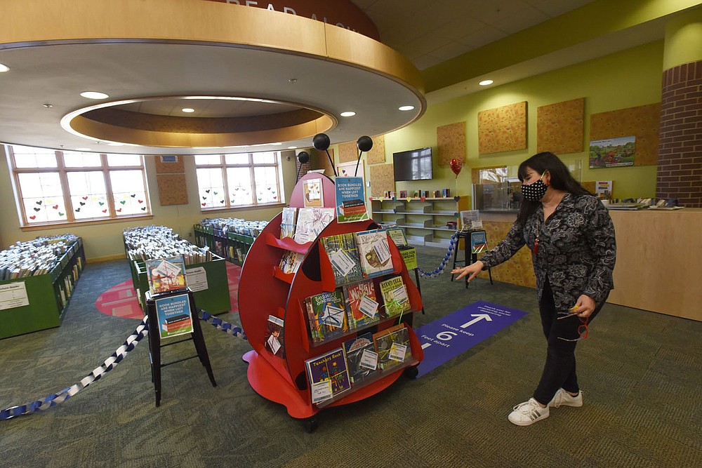 Asele Mack, library specialist at the Bentonville Public Library, shows Wednesday Feb. 24 2021 books available in the children's library area.
(NWA Democrat-Gazette/Flip Putthoff)