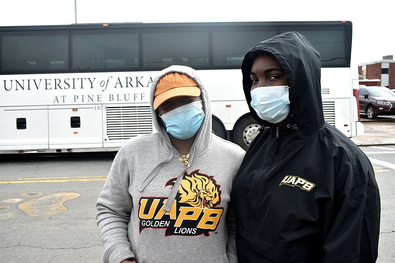 From left, freshmen Otisha Williams, 18, of Hartford, Conn., and Eboni Smith, 19, of Little Rock returned to campus before the third and final bus (pictured) dropped off students at Harrold Complex at the University of Arkansas at Pine Bluff on Sunday, Feb. 28, 2021. (Pine Bluff Commercial/I.C. Murrell)
