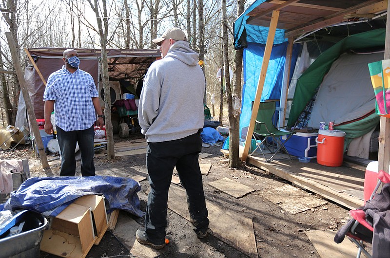 Ryan Pearson (left), outreach coordinator with the Northwest Arkansas Continuum of Care, speaks Thursday, February 25, 2021, with Will Daniels, a resident from a nearby neighborhood, at Daniel's friend's campsite at Safe Camp, the city-sanctioned encampment for people experiencing homelessness, in Fayetteville. Several area agencies worked to get unsheltered people out of record cold and heavy snowfall earlier this month and into hotels and shelters with food and transportation provided. Check out nwaonline.com/210228Daily/ and nwadg.com/photos for a photo gallery.
(NWA Democrat-Gazette/David Gottschalk)