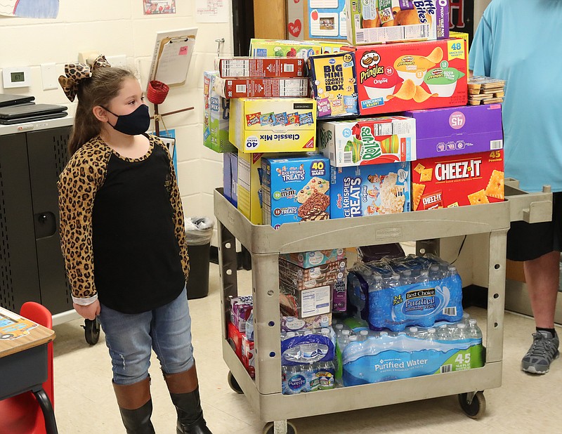 Lakeside Intermediate School student Paisley Melancon, 7, with all the snacks she bought her classmates Friday. - Photo by Richard Rasmussen of The Sentinel-Record