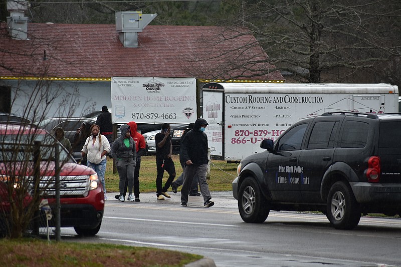 Bystanders walk down Sulphur Springs Road, across from the campus of Watson Chapel Junior High School, on Monday following a shooting at the school that a left a 15-year-old in serious condition. (Pine Bluff Commercial/I.C. Murrell)