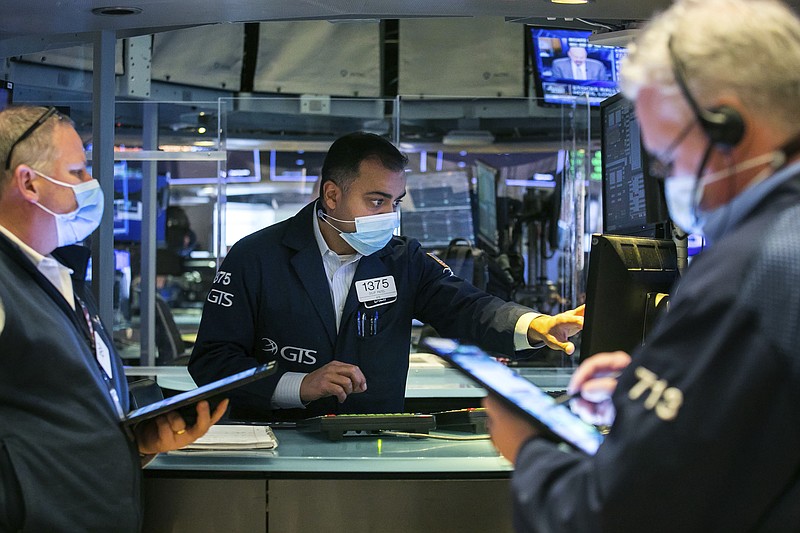 In this photo provided by the New York Stock Exchange, specialist Dilip Patel, center, works with traders on the floor, Monday, March 1, 2021. Stocks are rising across the board on Wall Street as traders welcomed a move lower in long-term interest rates in the bond market. Investors were also watching Washington as a big economic stimulus bill moved to the Senate. (Courtney Crow/New York Stock Exchange via AP)