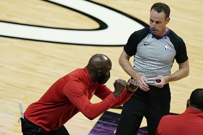 Atlanta Hawks head coach Lloyd Pierce, left, talks with official Josh Tiven, right, during the second half of an NBA basketball game against the Miami Heat, Sunday, Feb. 28, 2021, in Miami. (AP Photo/Lynne Sladky)