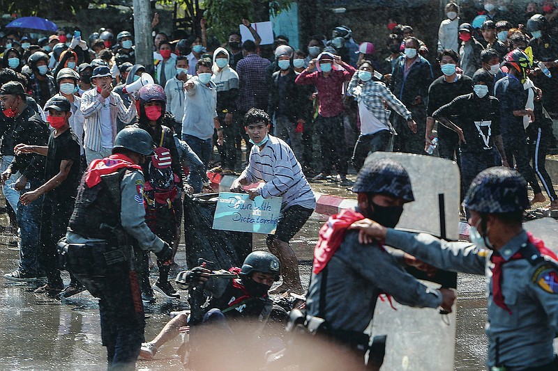 Protesters run after police shot warning shots and used water cannon to disperse them during a protest in Mandalay, Myanmar, Tuesday, Feb. 9, 2021. In the month since Feb. 1 coup, the mass protests occurring each day are a sharp reminder of the long and bloody struggle for democracy in a country where the military ruled directly for more than five decades. (AP Photo)