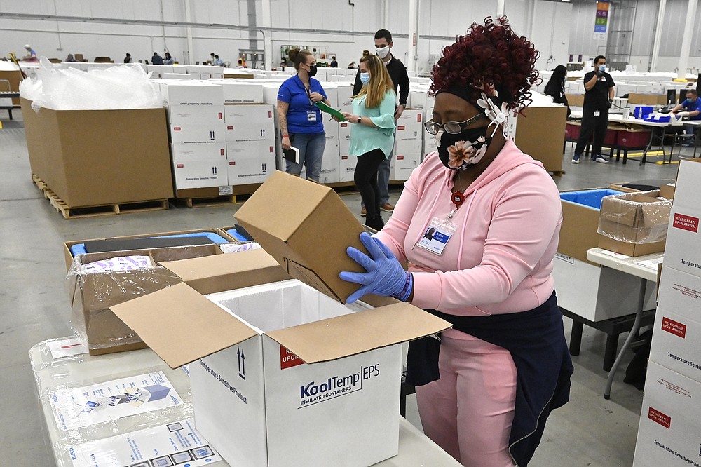 An employee with the McKesson Corporation packs a box of the Johnson and Johnson COVID-19 vaccine into a cooler for shipping from their facility in Shepherdsville, Ky., Monday, March 1, 2021. (AP Photo/Timothy D. Easley, Pool)
