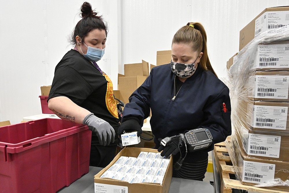 Employees with the McKesson Corporation scan a box of the Johnson &  Johnson COVID-19 vaccine while filling an order at their shipping facility in Shepherdsville, Ky., Monday, March 1, 2021. (AP Photo/Timothy D. Easley, Pool)