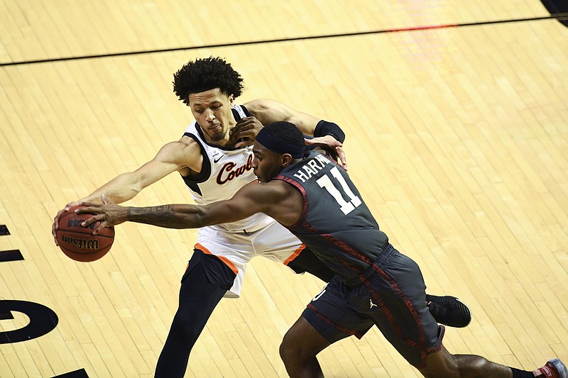 Oklahoma State guard Cade Cunningham (2) and Oklahoma guard De'Vion Harmon (11) reach for a loose ball during an NCAA college basketball game Monday, March 1, 2021, in Stillwater, Okla. (AP Photo/Brody Schmidt)